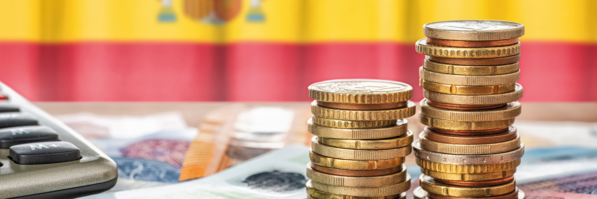Monedas y billetes de euro y de fondo bandera de España