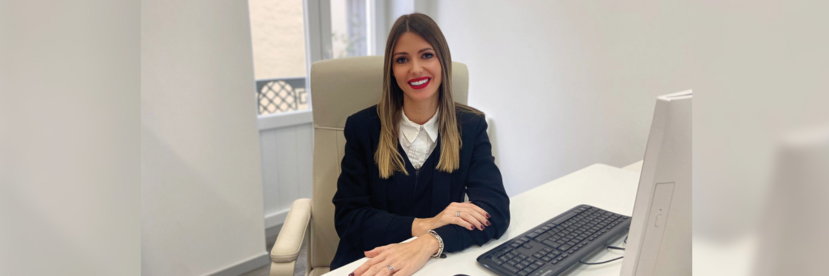 Foto de María Alcolea María Alcolea sentada en un escritorio con un teclado, ratón y monitor de computadora