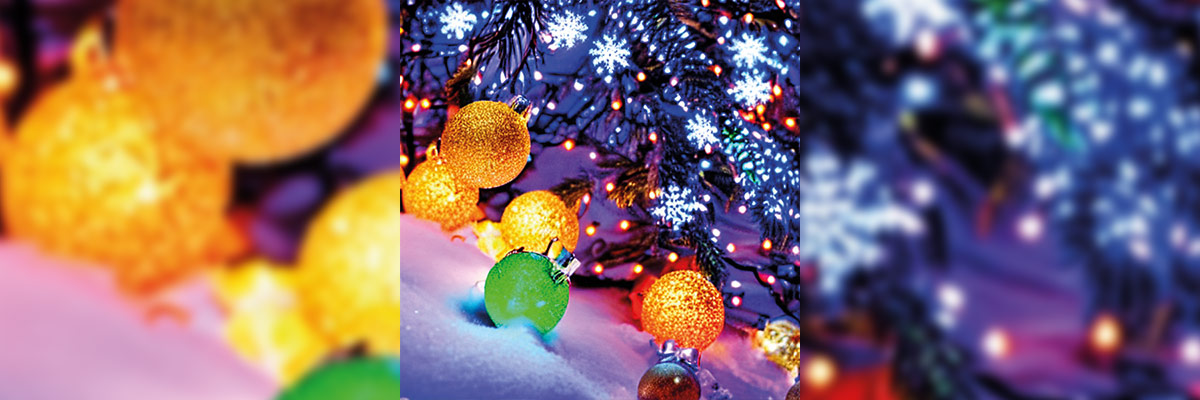 Luces de colores brillantes, algunas con forma de esfera, iluminan la nieve en una noche invernal, creando una atmósfera mágica y acogedora