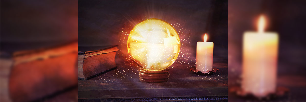 Conocimiento Iluminado Una escena mística que muestra un antiguo libro, una bola de cristal radiante que emana destellos de luz y dos velas encendidas sobre una superficie de madera