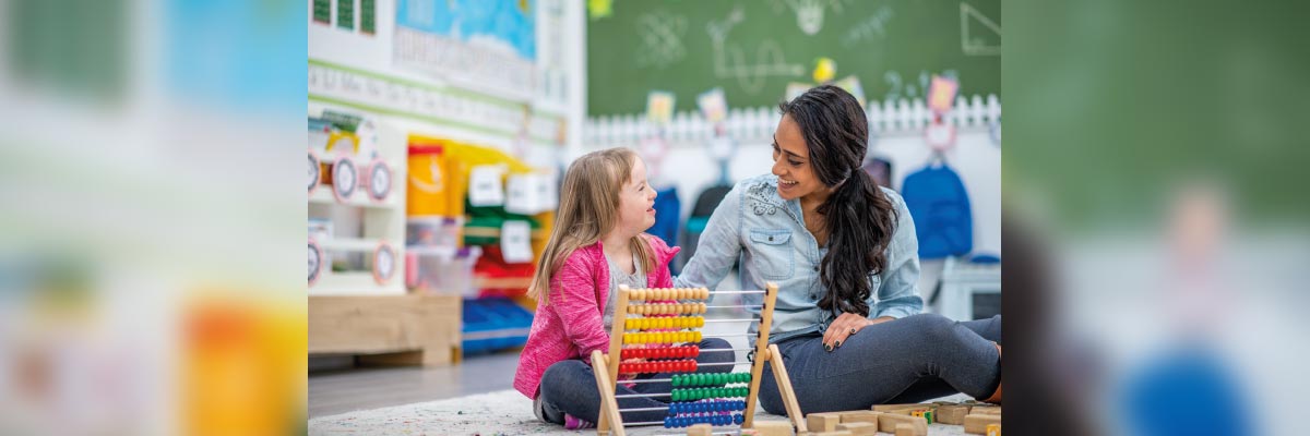 Profesora jugando con una niña con discapacidad intelectual