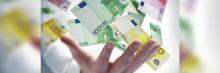 Mano y billetes de 100 y 200 euros