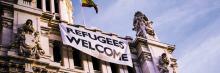 Edificio de correos. Ayuntamiento de Madrid con la bandera de bienvenidos refugiados
