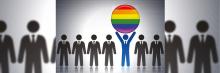 Siluetas de personas sosteniendo una bola con los colores LGTBI