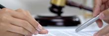 Ponencia fiscal — novedades tributarias Manos firmando documento junto a mazo de juez, símbolo de sentencias, consultas y novedades en materia tributaria.