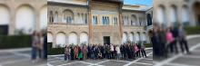 Un grupo de personas se reúne frente a un edificio histórico con arquitectura detallada, posando para una foto en una plaza pavimentada