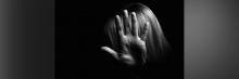 Mujer en la oscuridad con la mano en la cara
